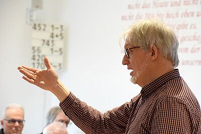 Ein älterer Herr der etwas erklärt