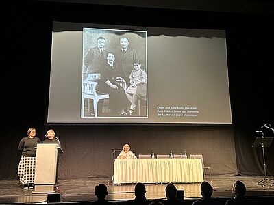3 Personen auf einer Bühne, die etwas präsentieren