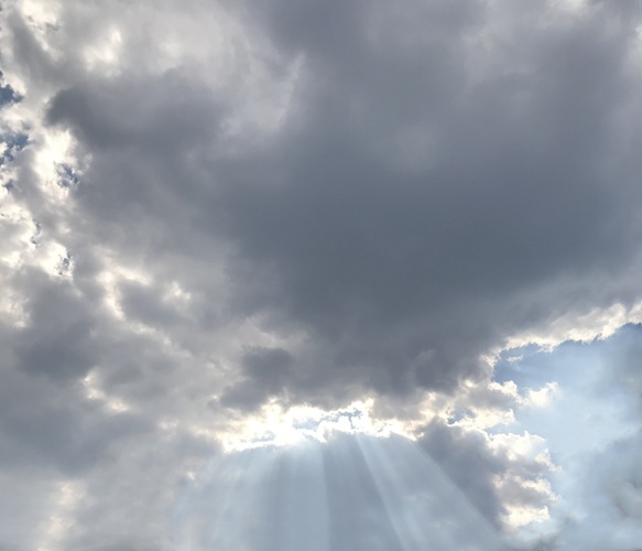 Sonnenstrahlen durchbrechen eine Wolkenwand